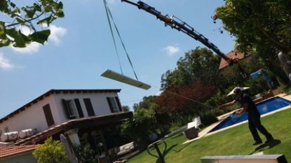 מנוף מוריד את קורות הברזל לפרגולה